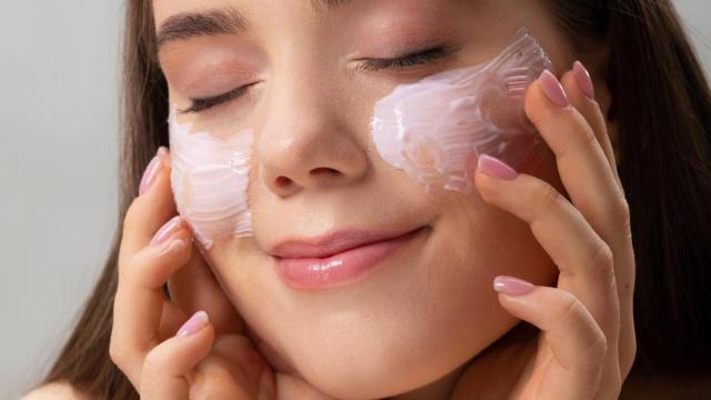 Mujer aplicándose un producto facial.
