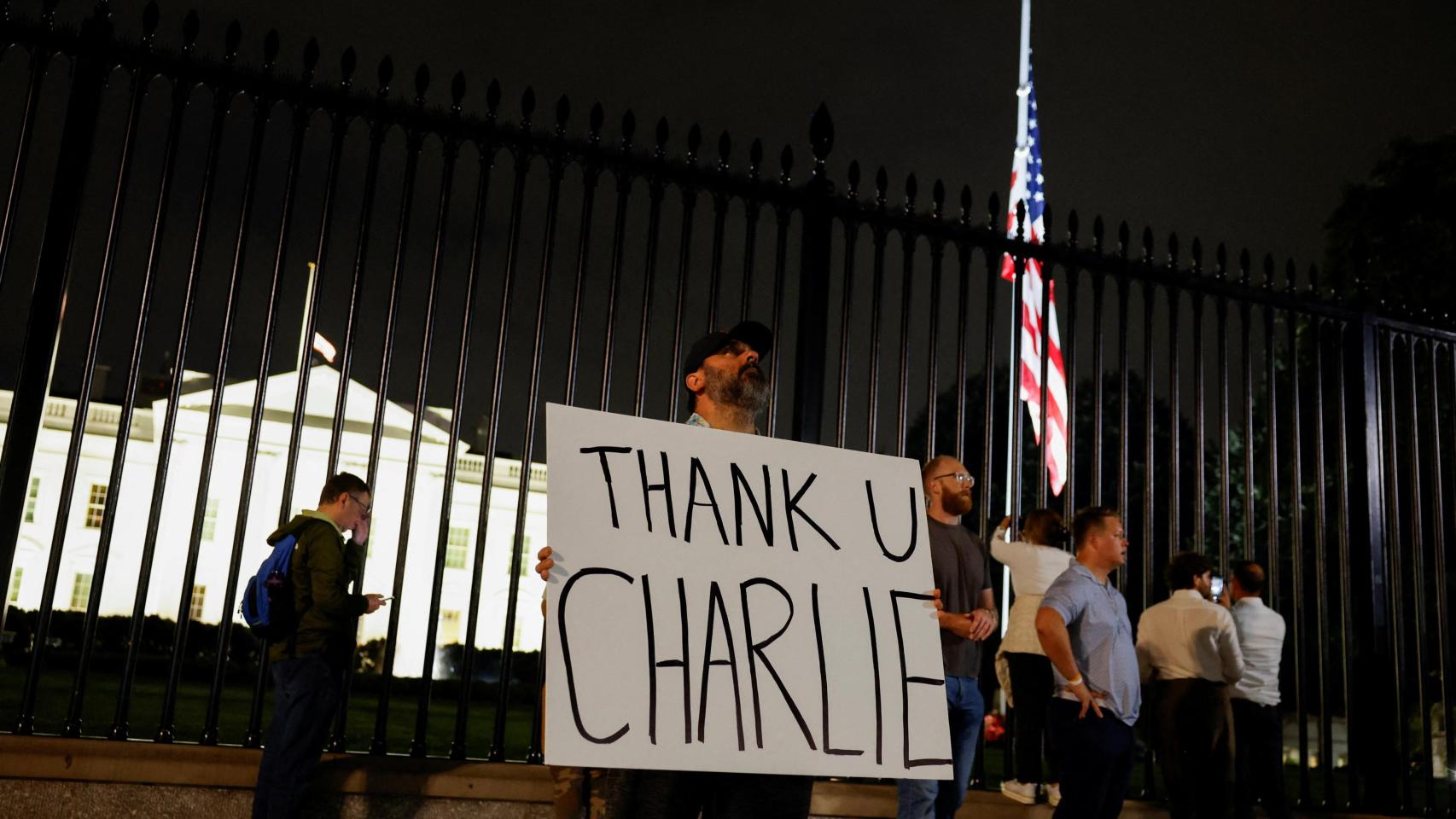 Un hombre sostiene un cartel de agradecimiento a Charlie Kirk frente a la Casa Blanca.