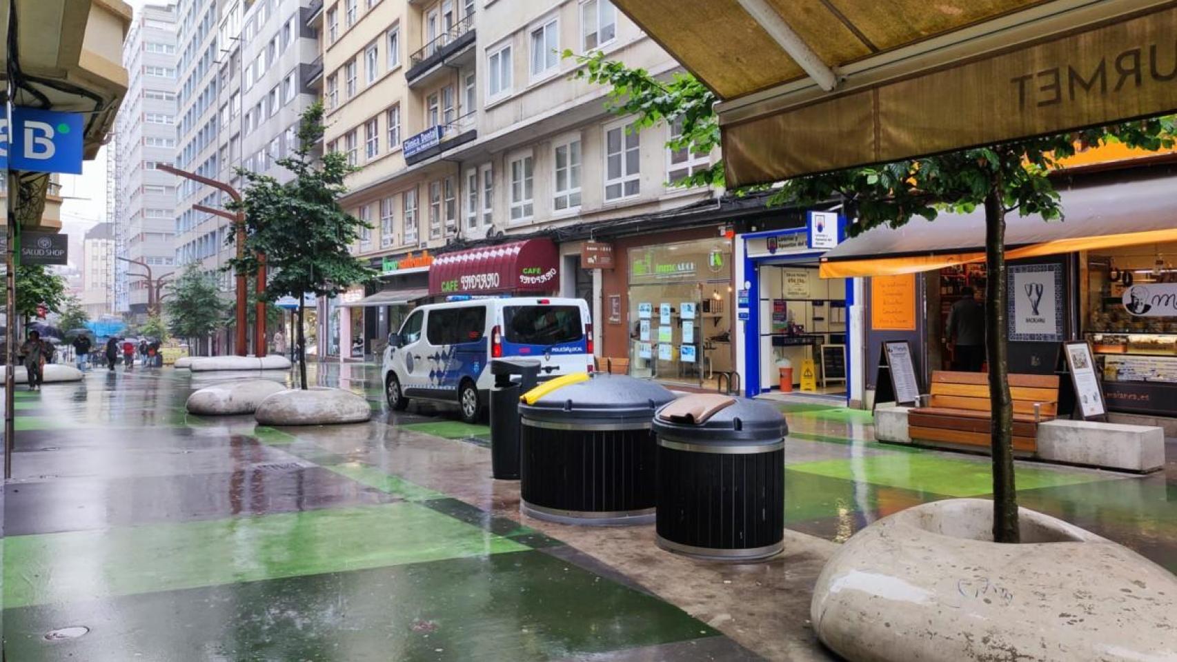 Un coche policial circula por la renovada calle peatonal Alcalde Marchesi, en A Coruña.