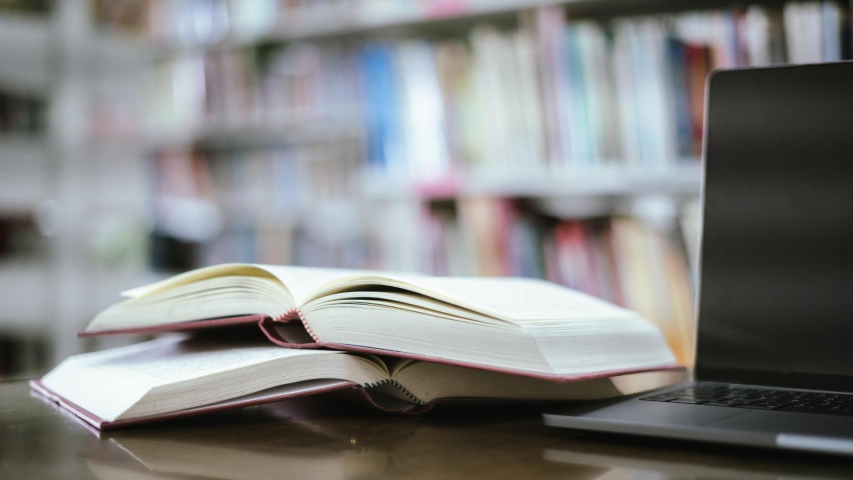 Dos libros y un ordenador portátil en primer plano.