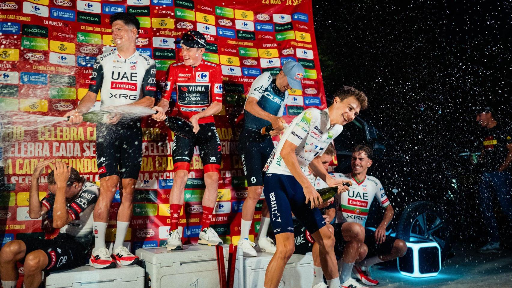 Vingegaard, Almeida y el resto de triunfadores en La Vuelta en el podio improvisado descorchando el champán.