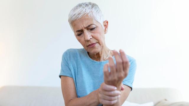 Mujer mayor con dolor en la mano por artritis.