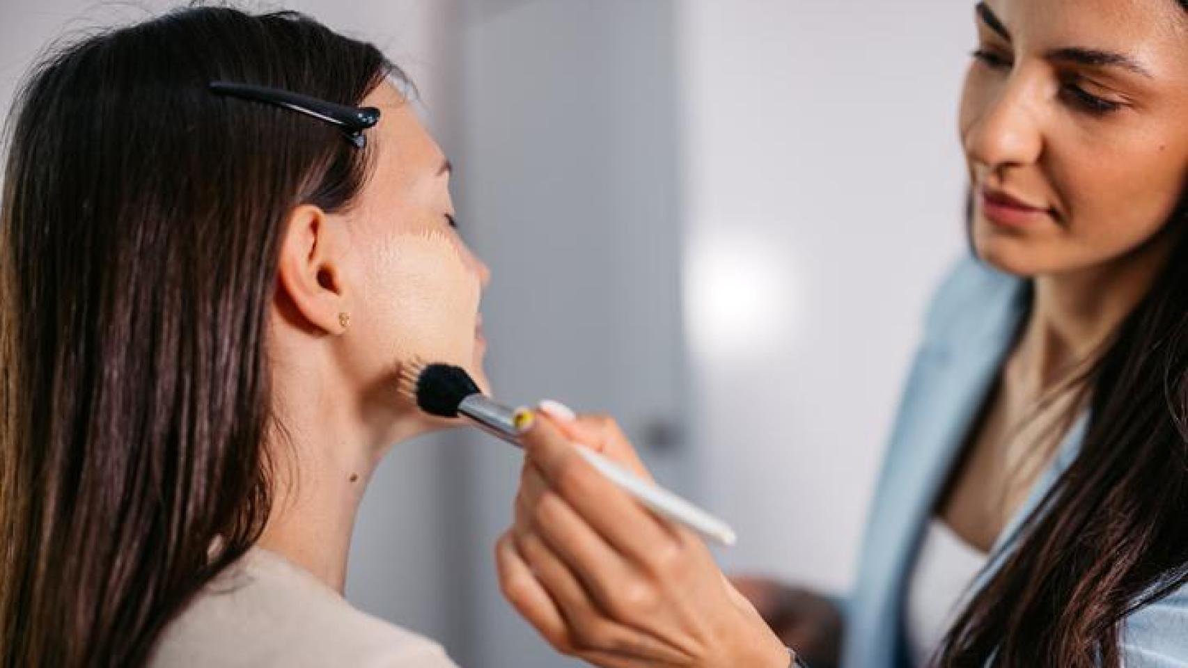 Mujer siendo maquillada por una profesional.