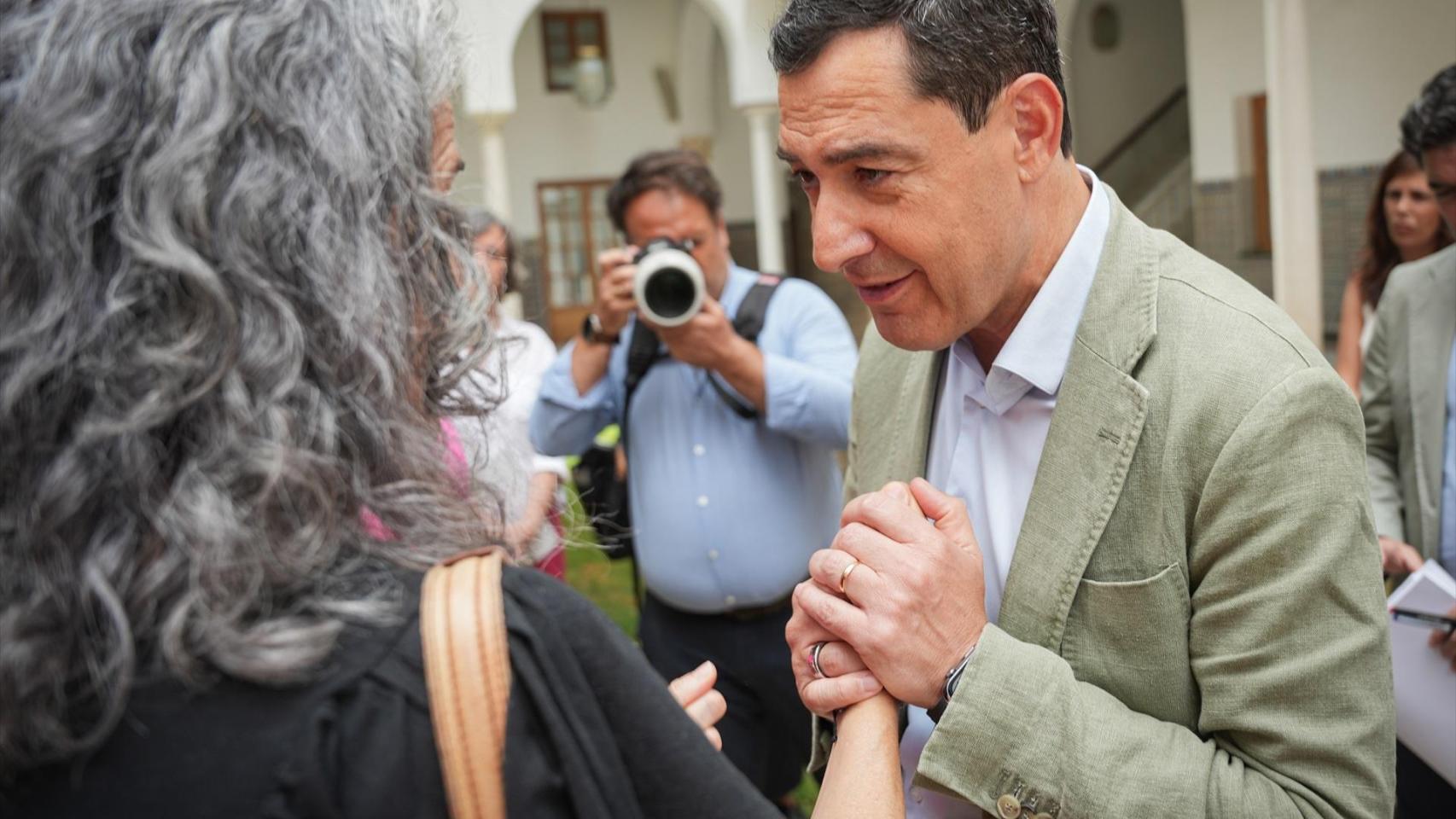 Juanma Moreno con las madres a las que prometió la puesta en marcha del servicio el pasao mes de julio.