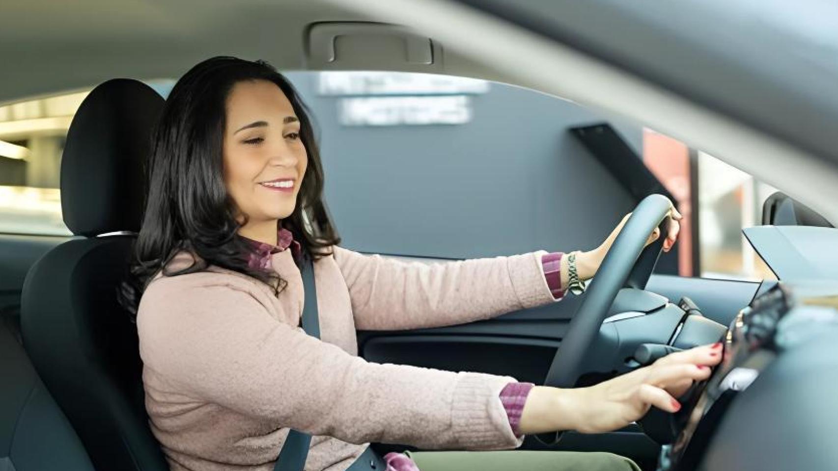 Conductora usando el aire acondicionado.