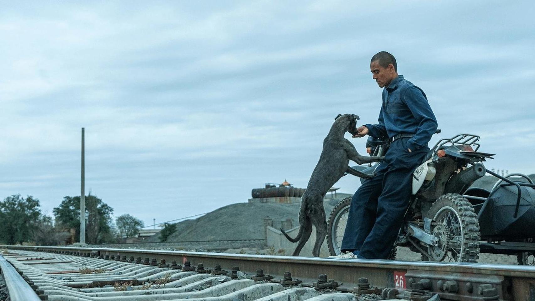 El actor Eddie Peng con el perro negro Xin, el coprotagonista canino, en una escena de 'Black Dog'.