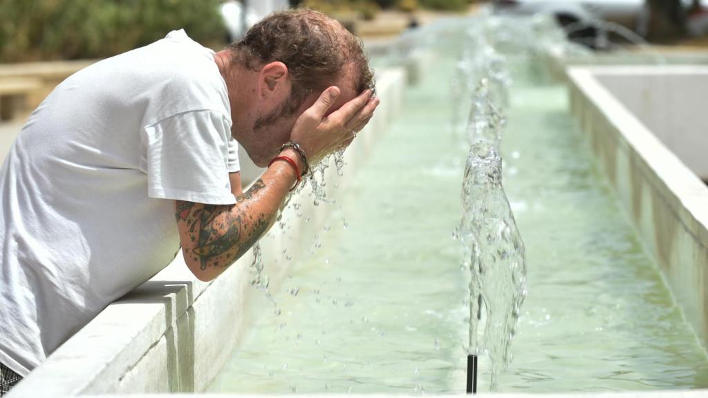 Un hombre se refresca en una fuente, a 10 de agosto de 2023, en Murcia.