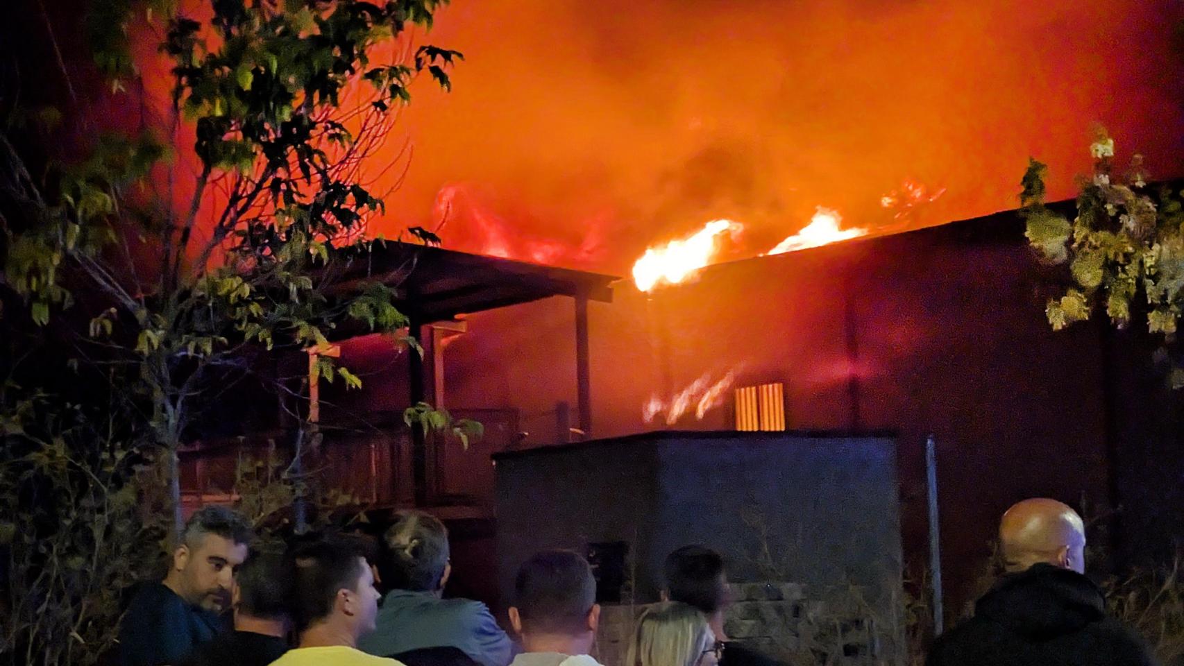 Varias personas observan el incendio de la nave para vehículos agrícolas en Ciudad Rodrigo (Salamanca))