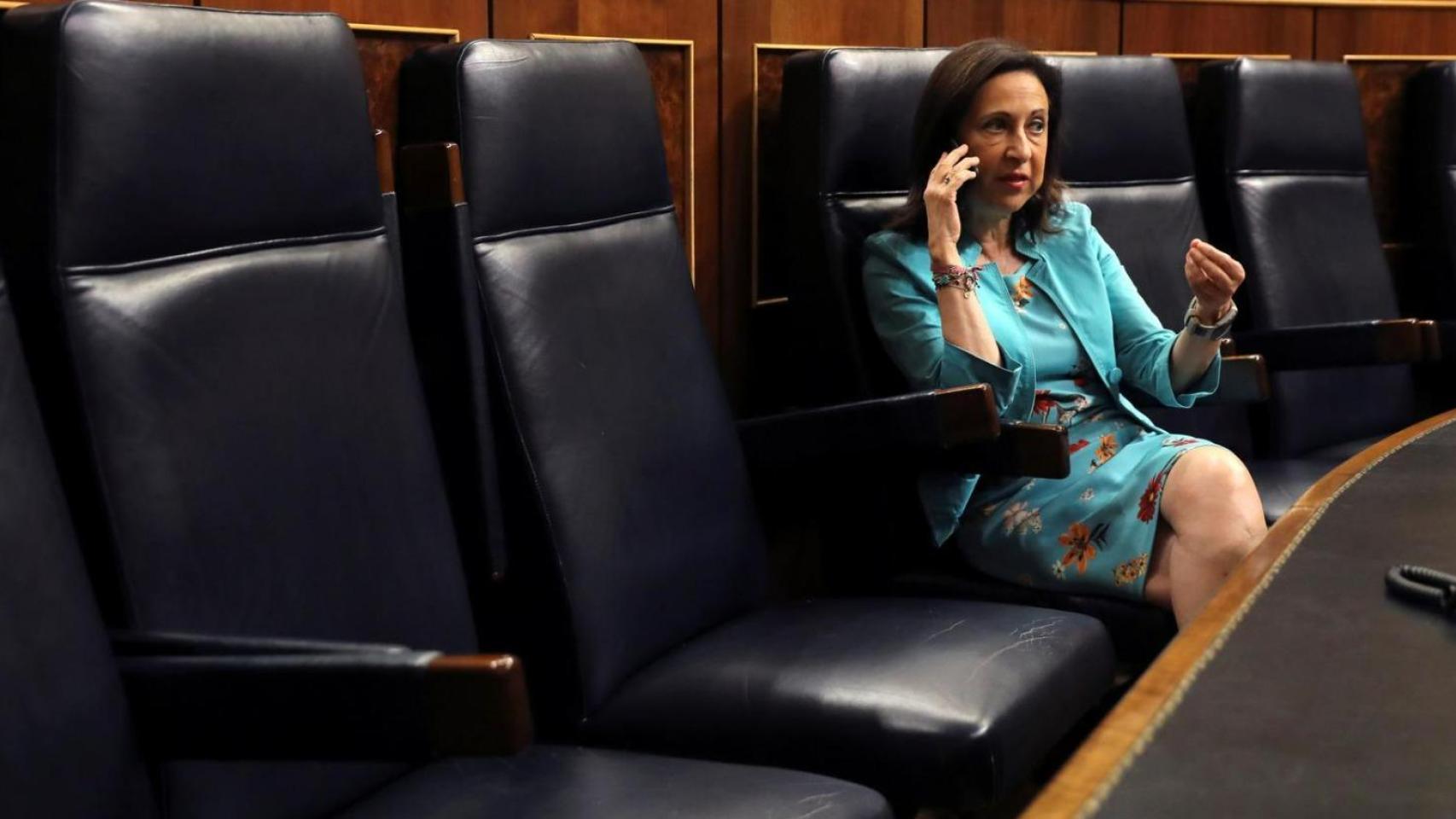 La ministra de Defensa, Margarita Robles, habla por su móvil desde el banco azul del Congreso de los Diputados.