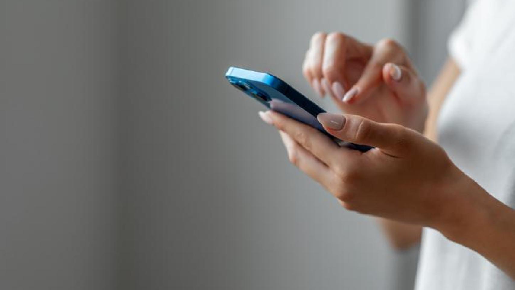 Mujer con el móvil entre las manos.