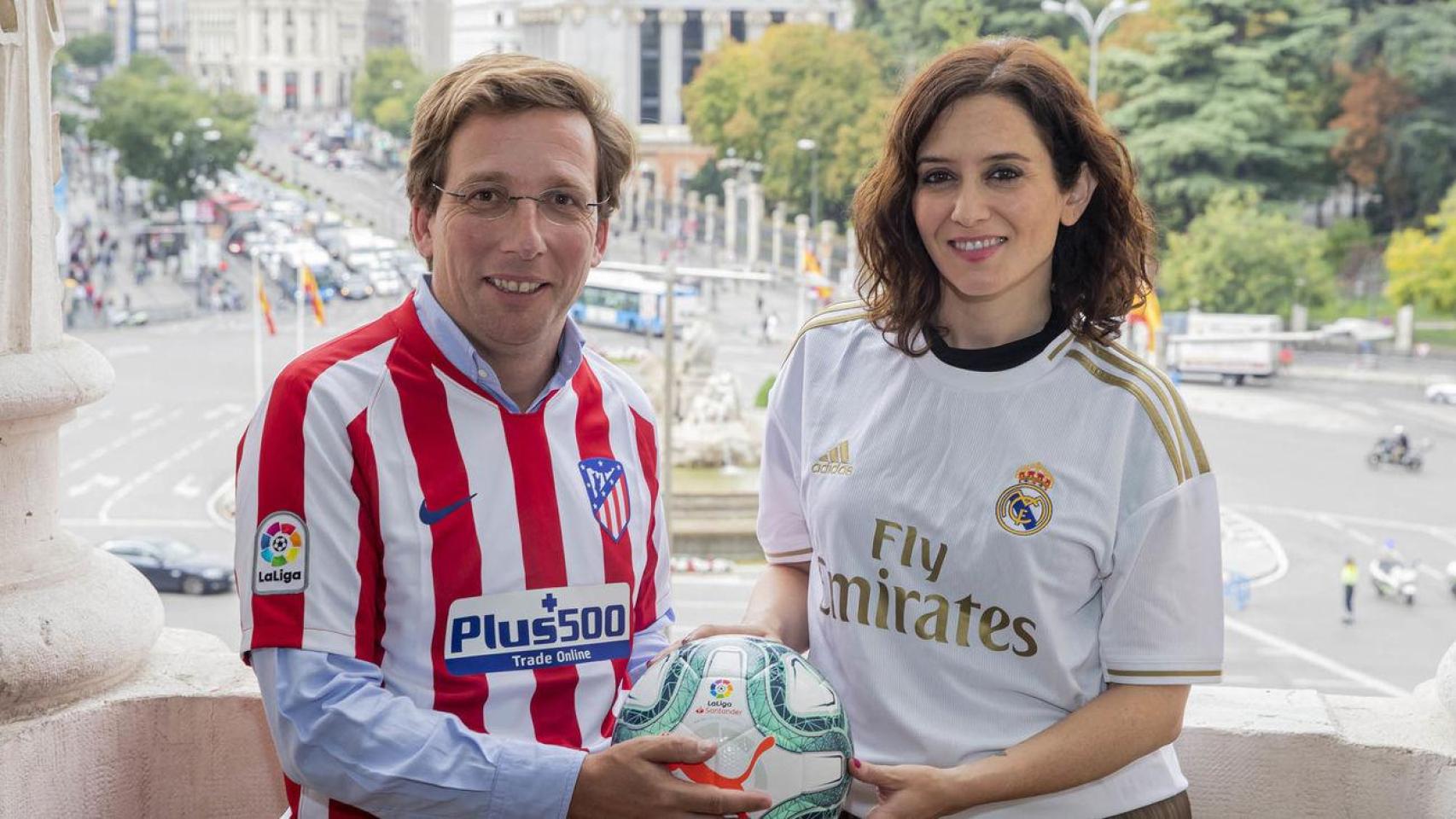José Luis Martínez Almeida e Isabel Diaz Ayuso con las camisetas del Atlético y del Real Madrid respectivamente.