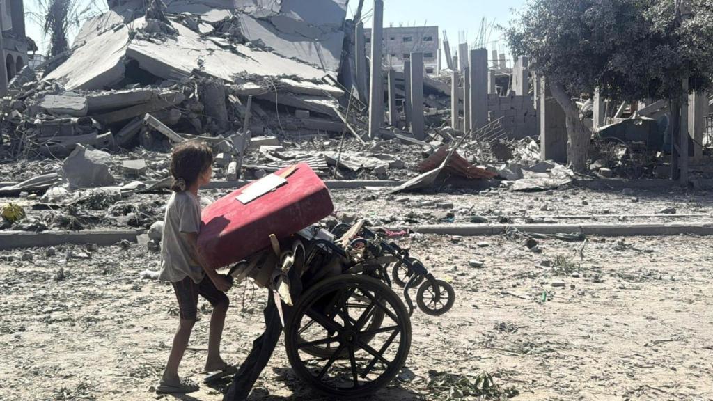 A girl pushes a wheelchair in gaza