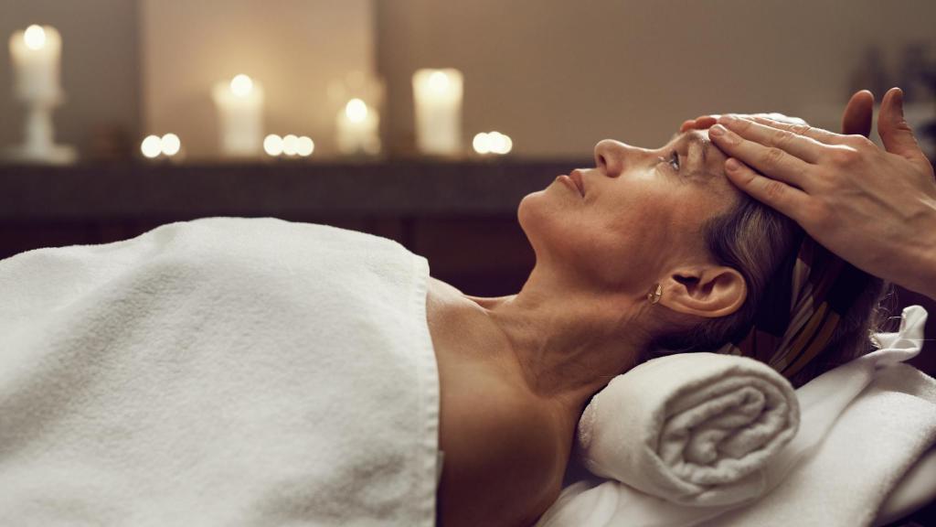 Una mujer realizándose un masaje.