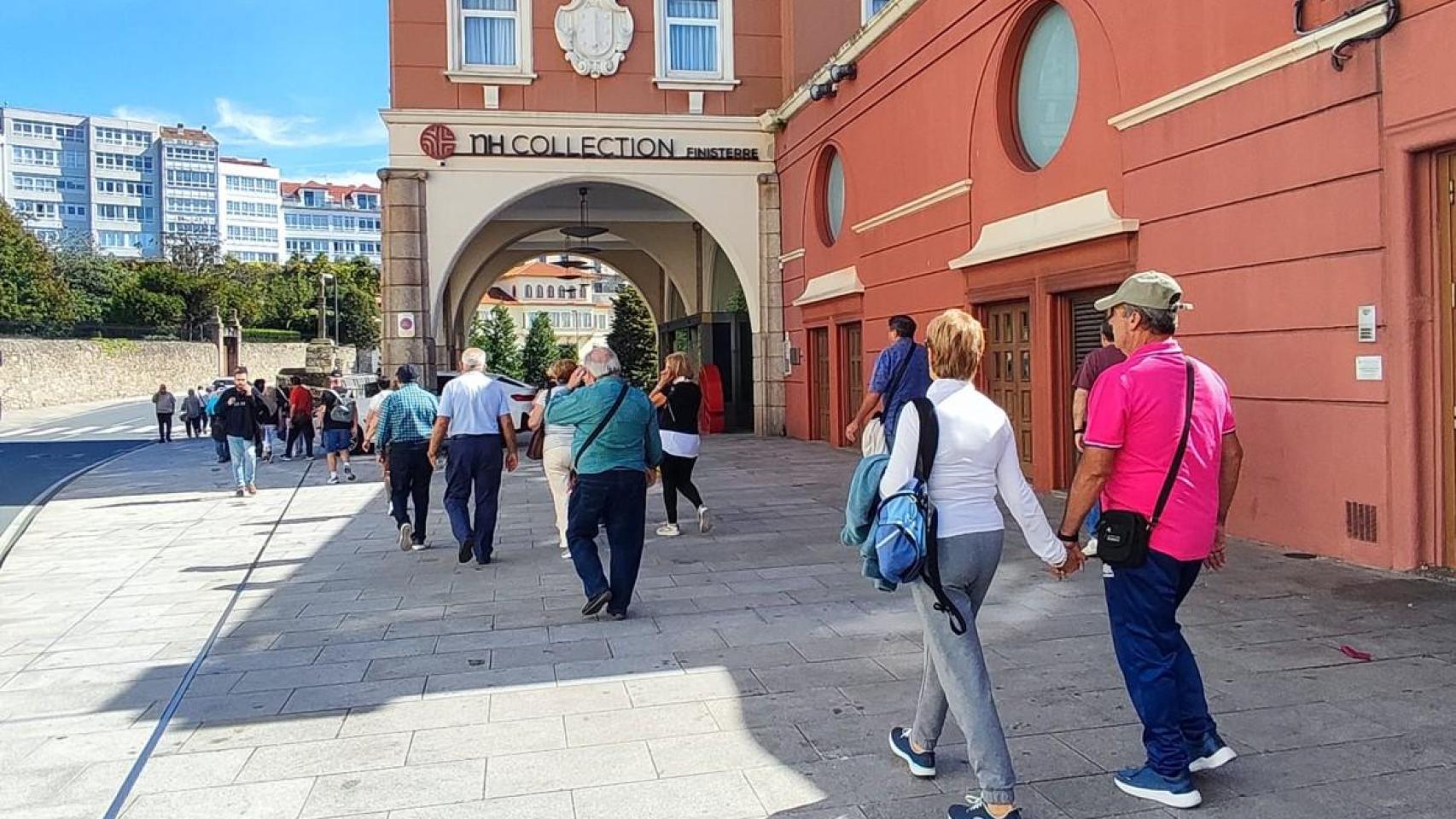 Turistas pasean en grupo delante del hotel NH Finisterre de A Coruña.