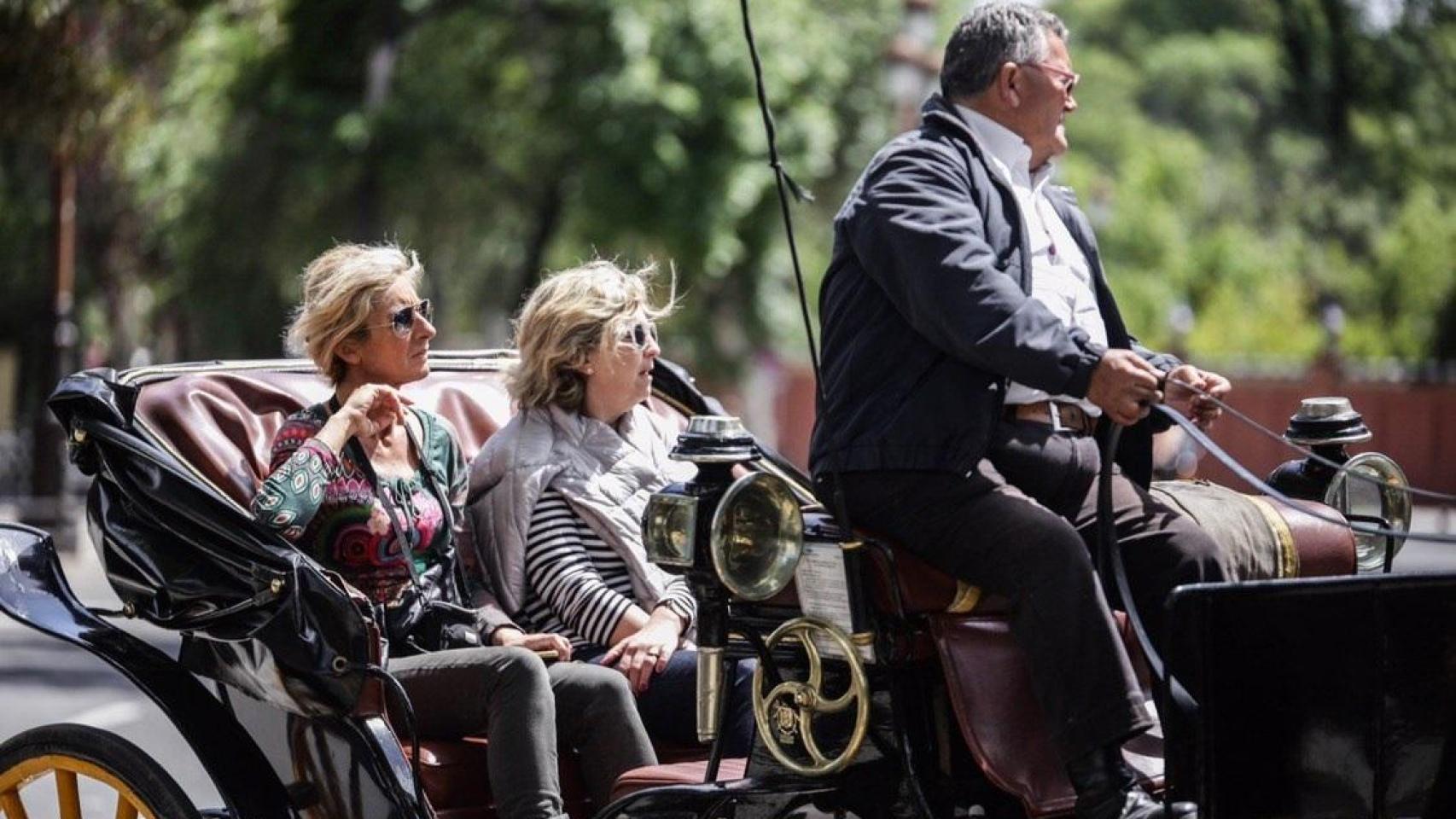 Imagen de dos mujeres dando un paseo en un coche de caballos.