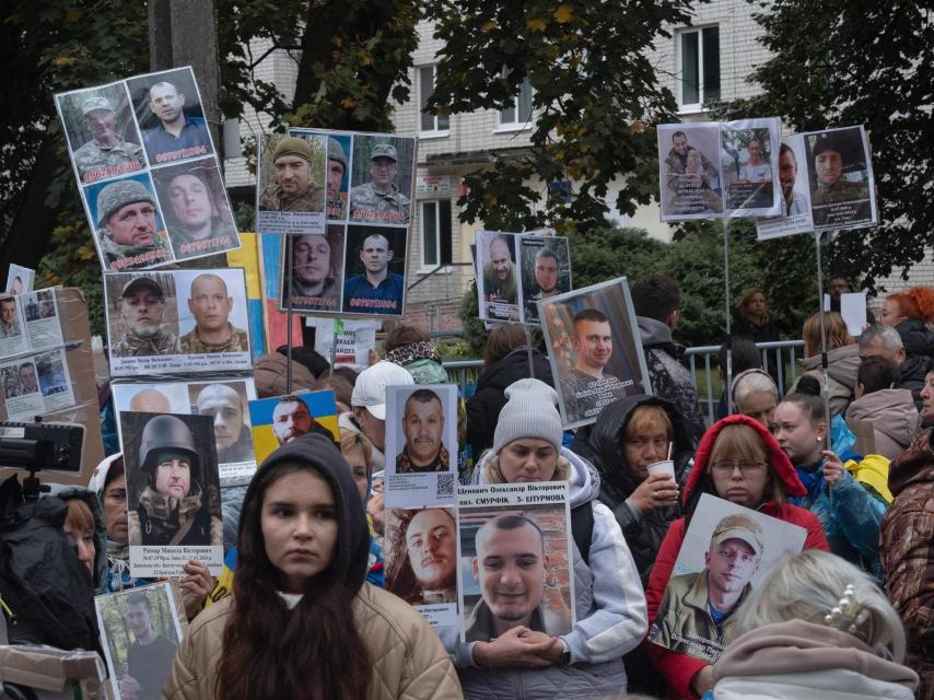 Relatives of Ukrainian prisoners of war and missing in action attend an exchange seeking information about their loved ones and showing their portraits.