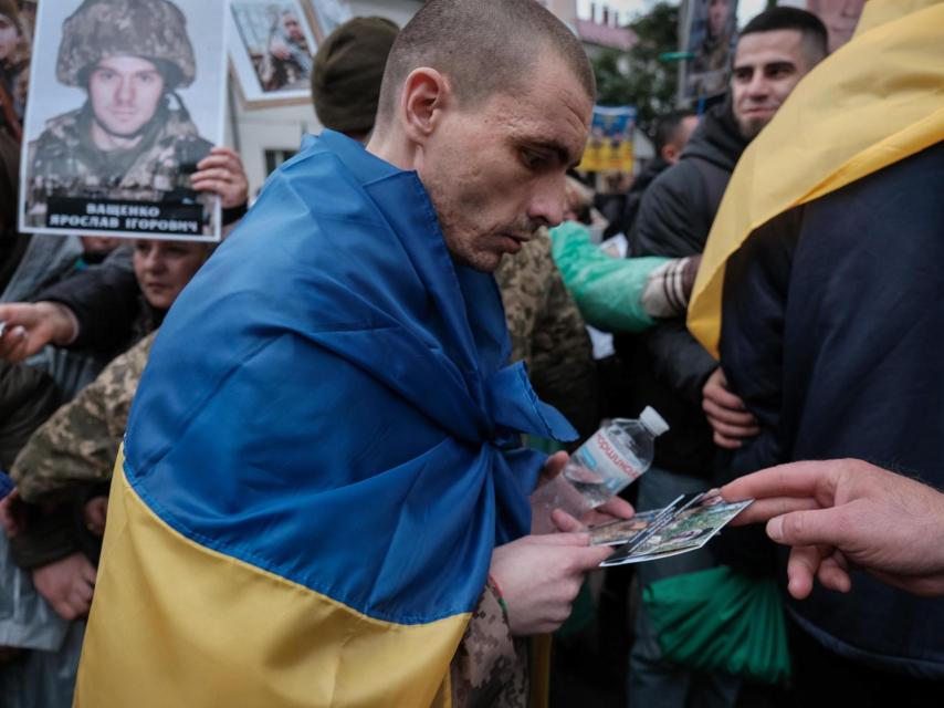 A recently released Ukrainian prisoner of war collects portraits given to him by the families of other captive or missing soldiers, who hope he recognizes someone.