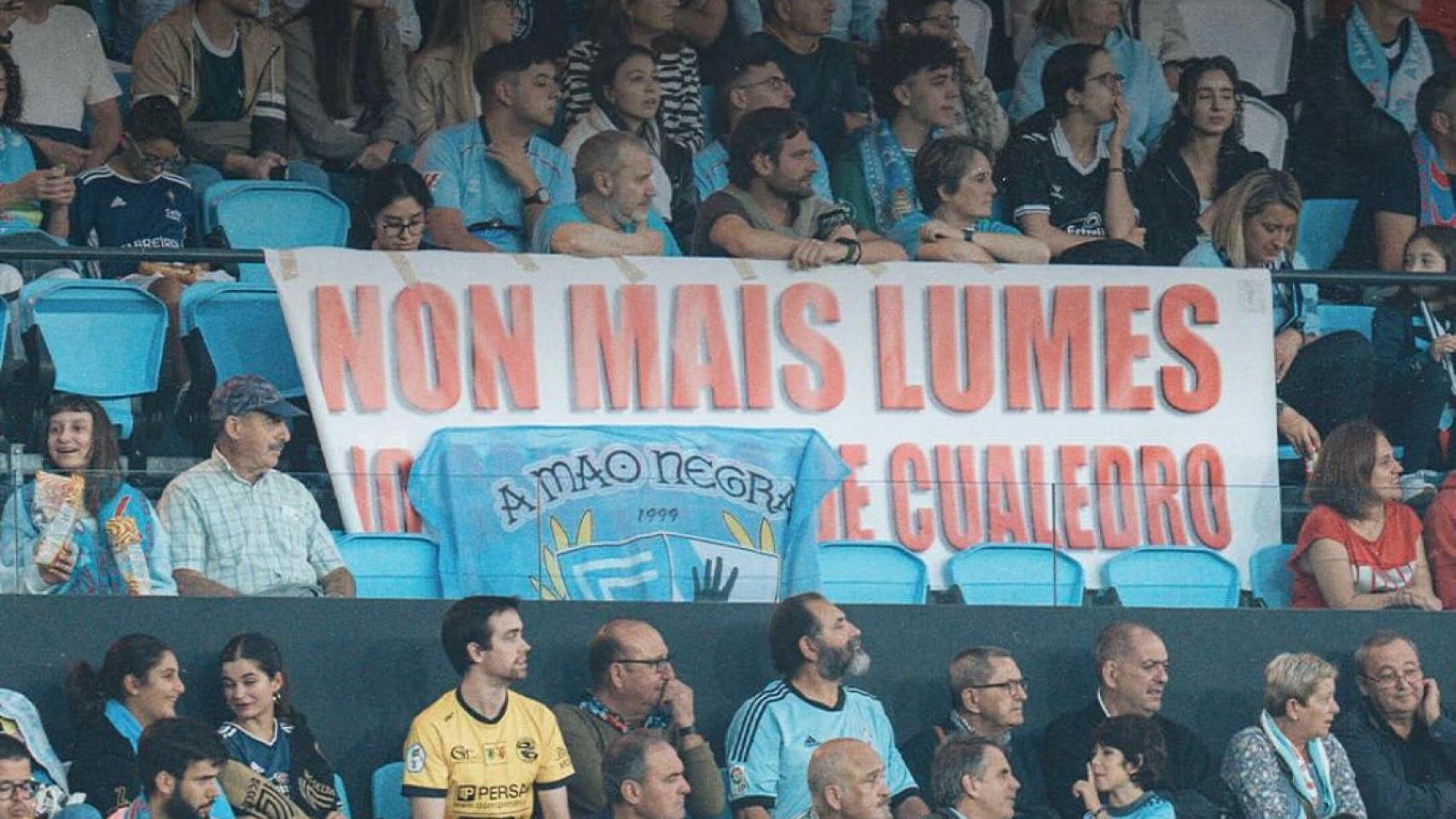 Aficionados en el partido detrás de una pancarta contra los incendios en Ourense