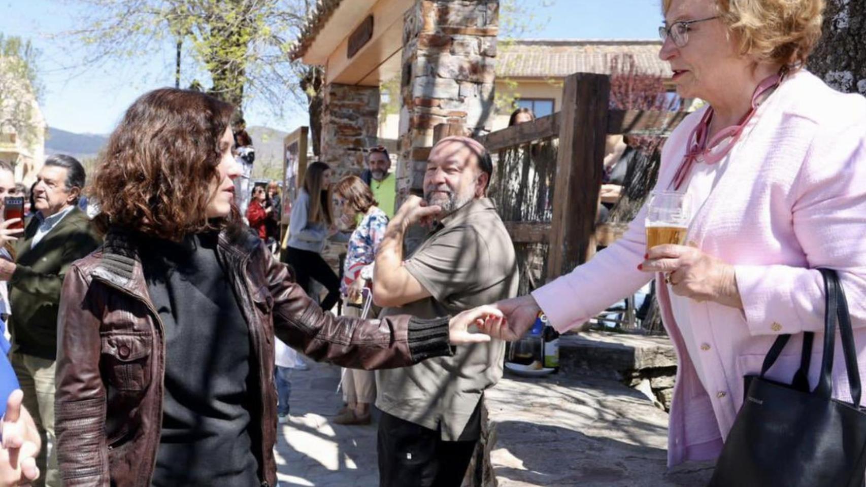 Ayuso saluda a una vecina de Madarcos, el pueblo con menos habitantes de la Comunidad de Madrid.