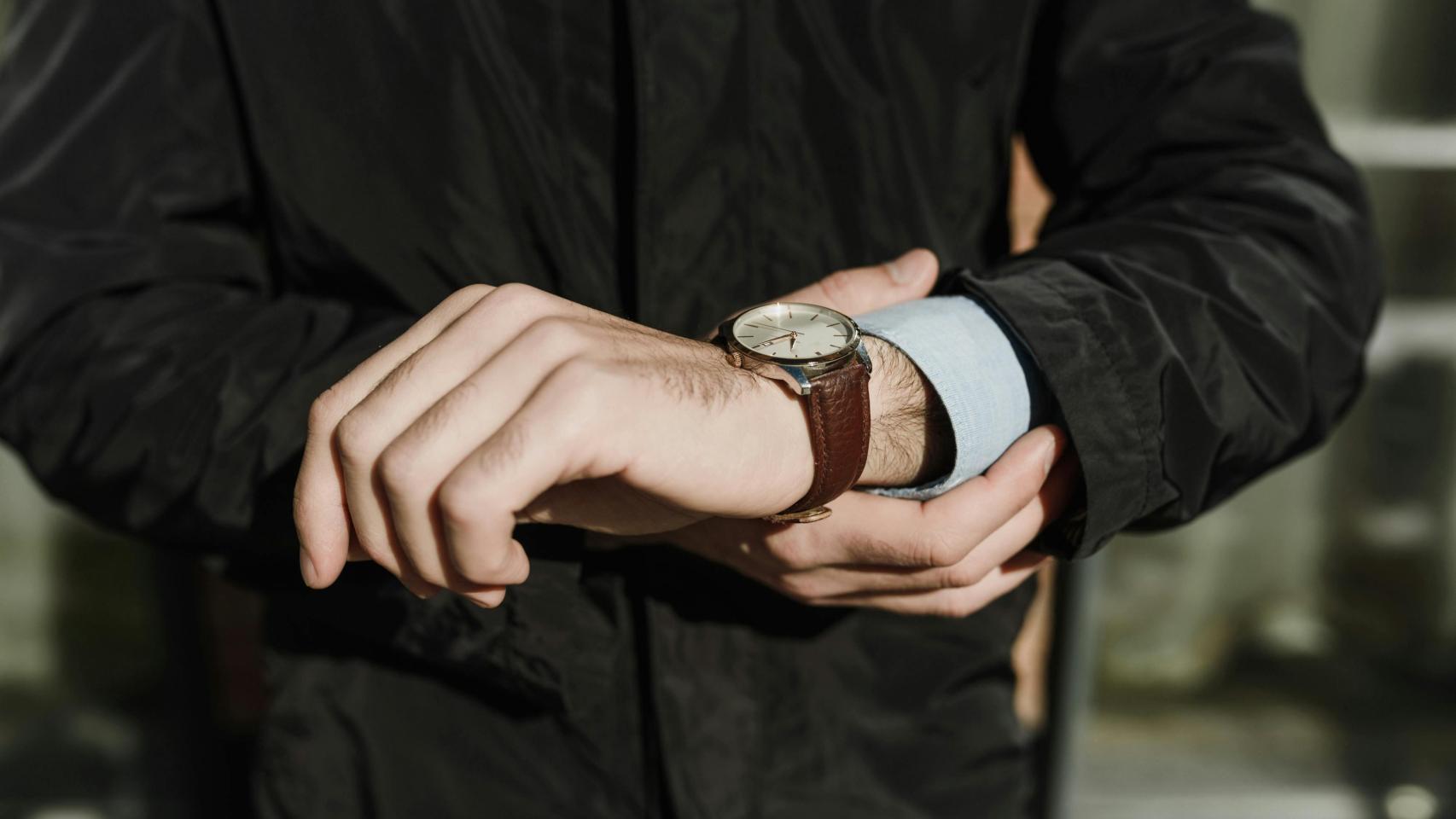 Un hombre consulta su reloj.