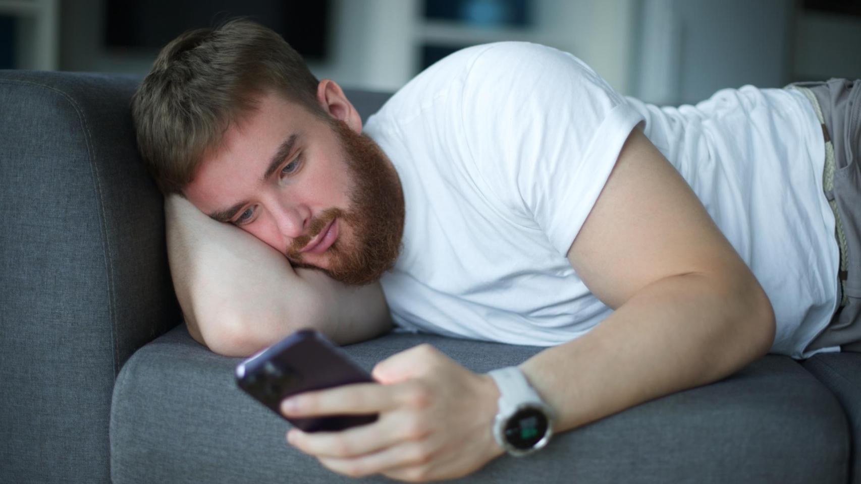 Un joven adulto con el móvil