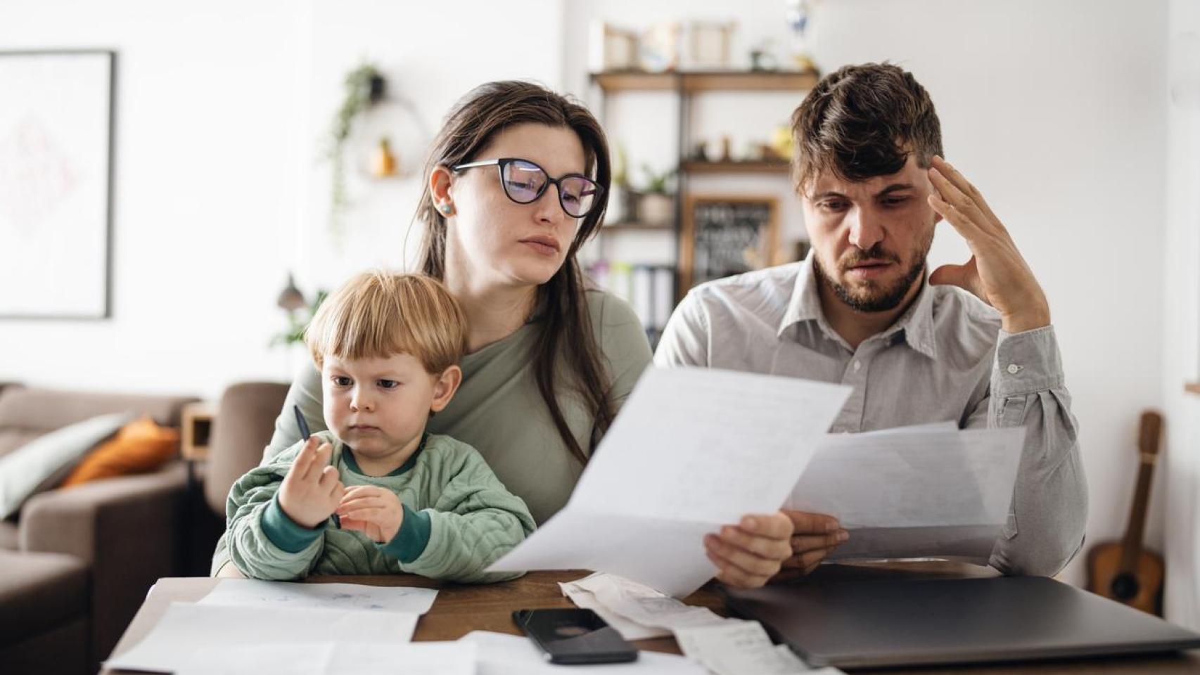 Padres jóvenes revisando facturas.