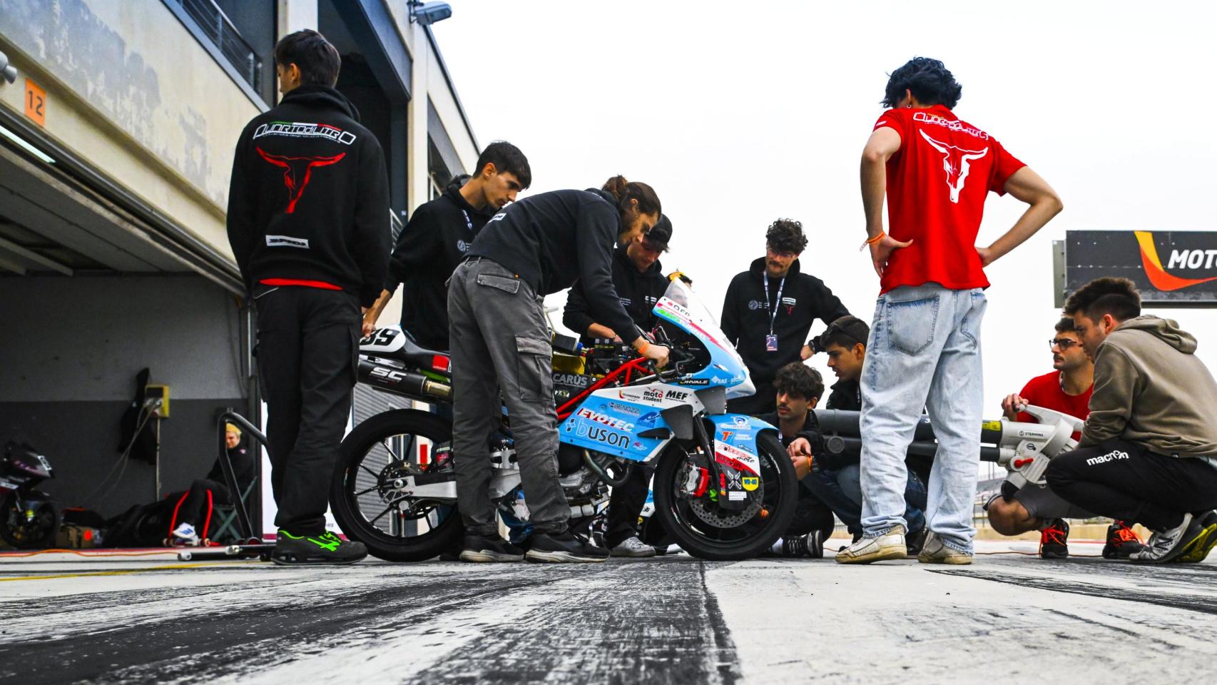 Varios ingenieros inspeccionan una moto durante la competición.