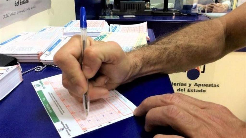 Imagen de un jugador rellenando un boleto de La Primitiva.