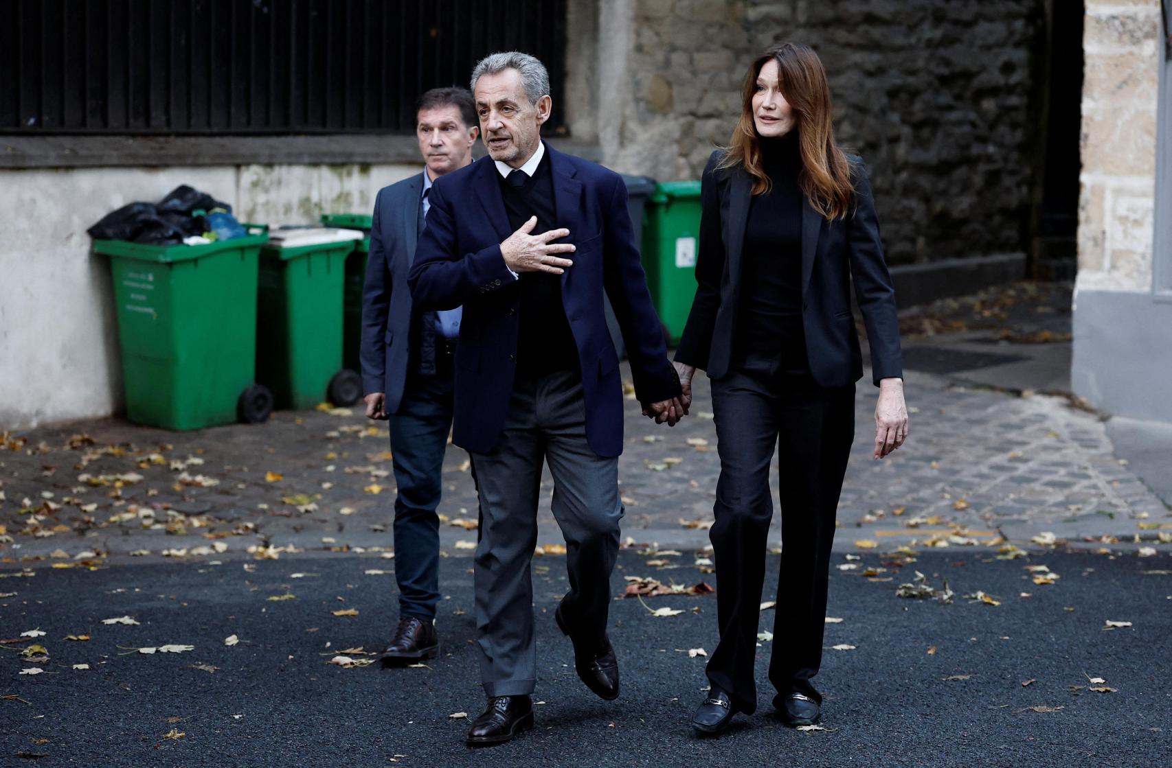 Nicolas Sarkozy leaving his house with his wife, Carla Bruni.