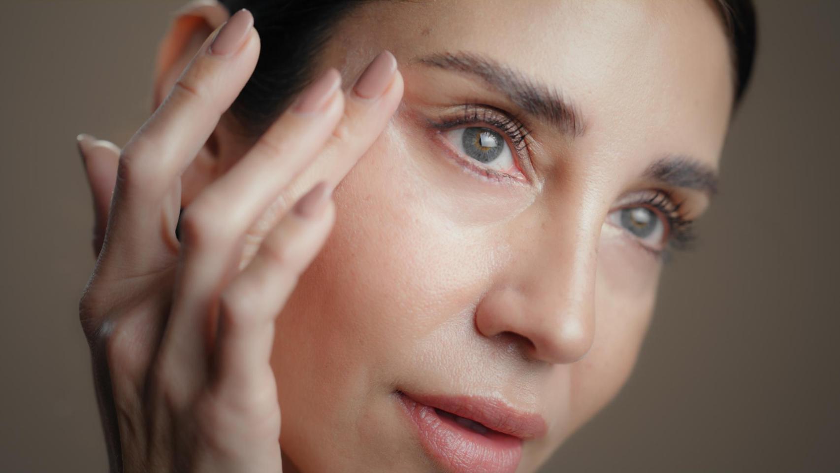 Imagen de archivo de una chica aplicándose sus cuidados faciales.
