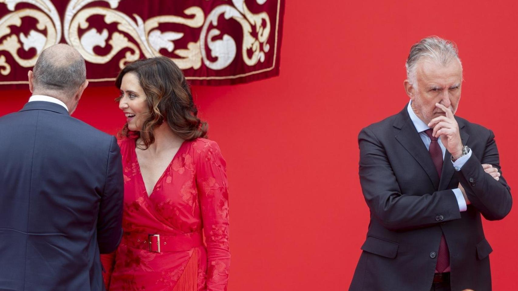 La presidenta de la Comunidad de Madrid, Isabel Díaz Ayuso, habla con el presidente del Senado, Pedro Rollán, junto al ministro de Política Territorial y Memoria Democrática, Ángel Víctor Torres,