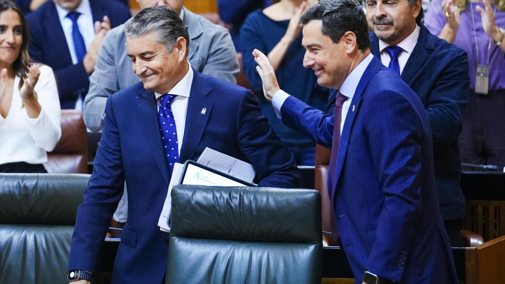 El presidente de la Junta, Juanma Moreno, saluda al consejero de Sanidad en el Parlamento de Andalucía.