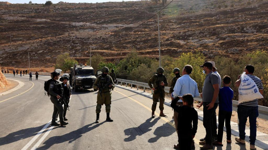 Israeli Army soldiers prevent Palestinian pickers from accessing olive groves in the occupied West Bank.