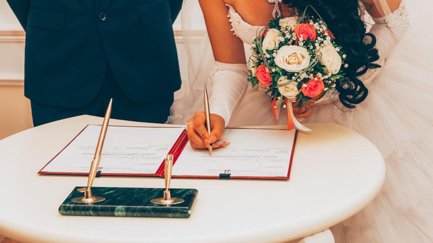 Pareja firmando papeles de casados.