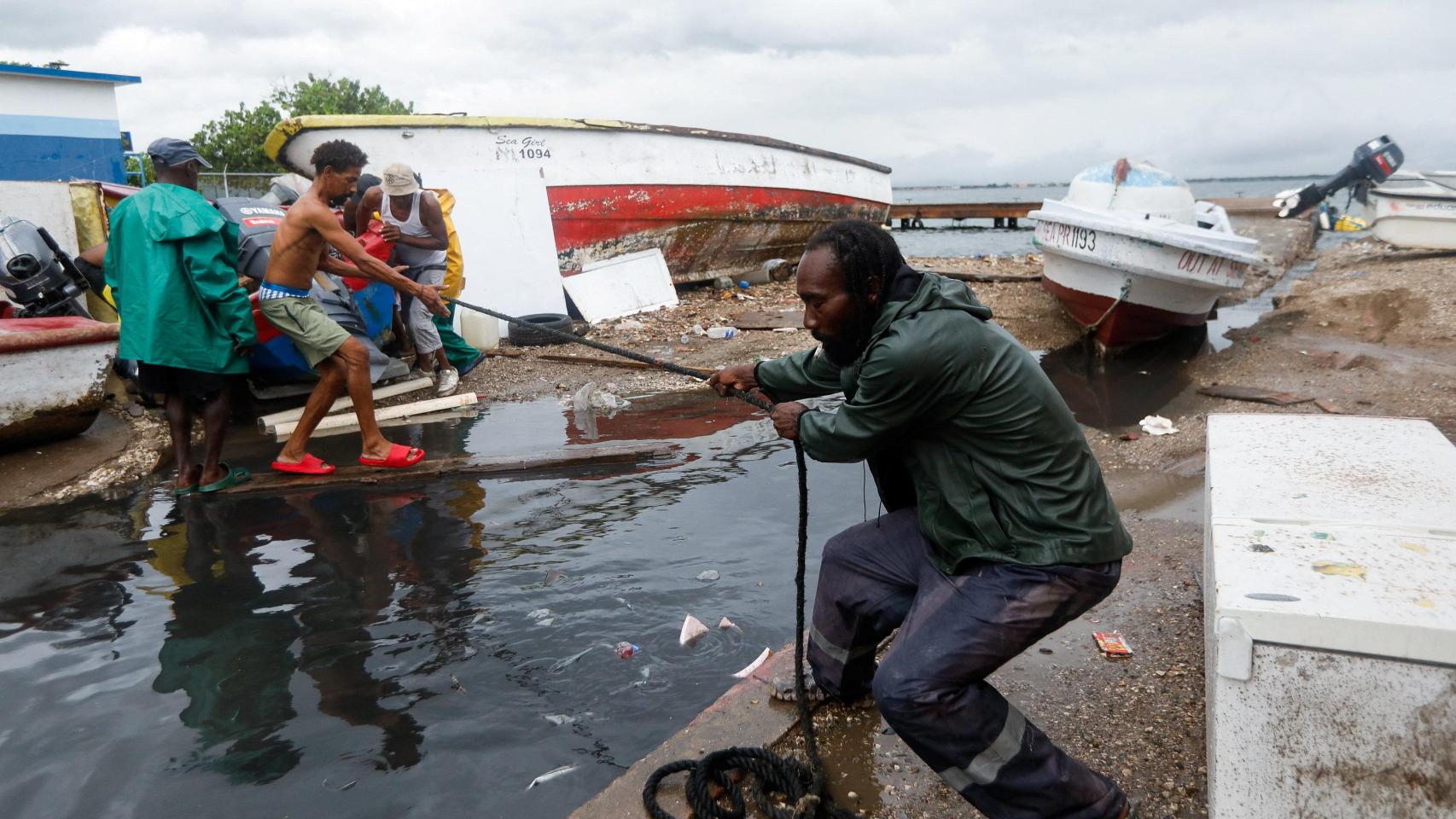 Un grupo de jamaicanos se prepara para la llegada del huracán Melissa.