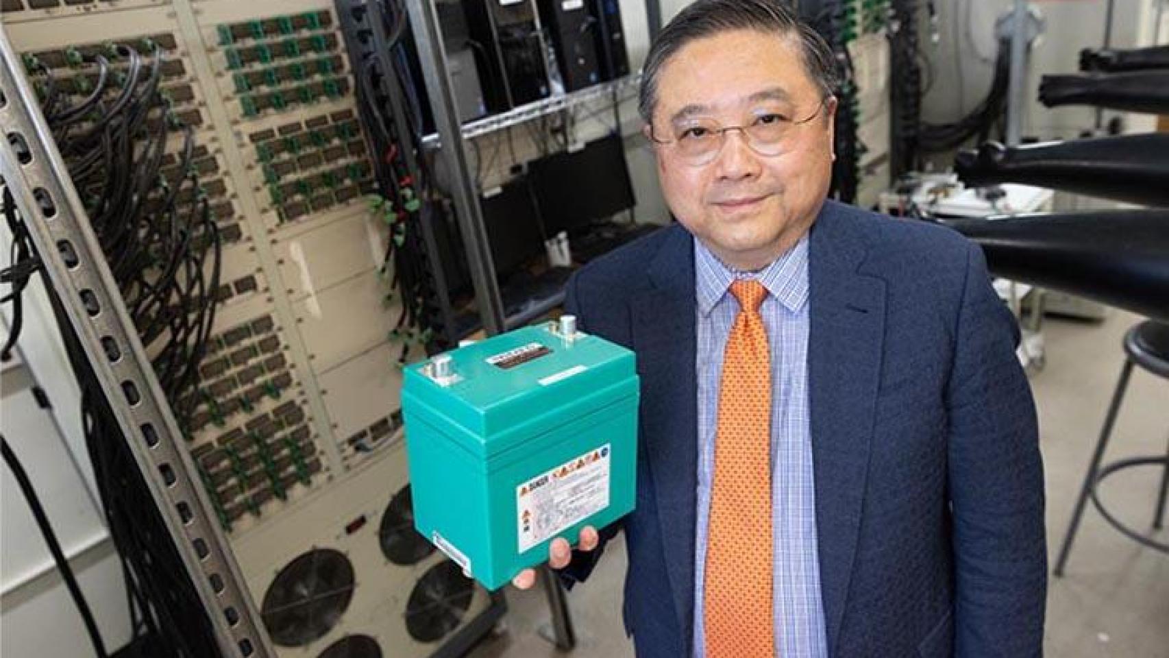 Deyang Qu, profesor de ingeniería mecánica en la UWM, sostiene una batería de fosfato de hierro y litio