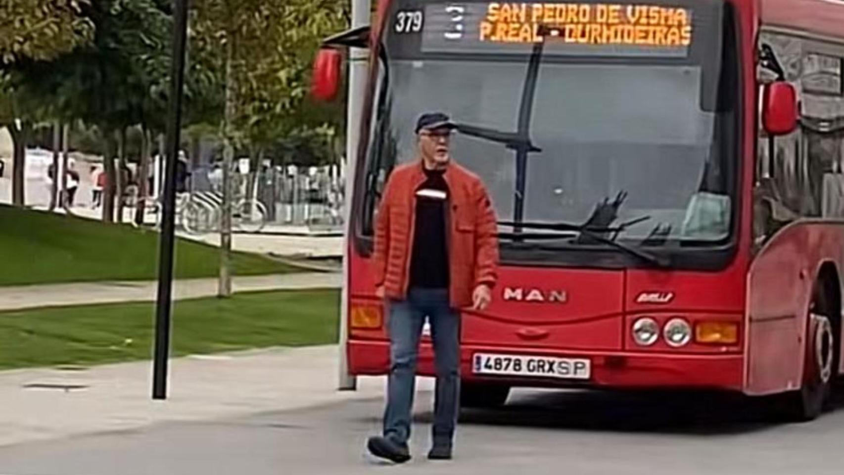 Un hombre pasea por la carretera de la Marina sin darse cuenta de que tiene un bus detrás
