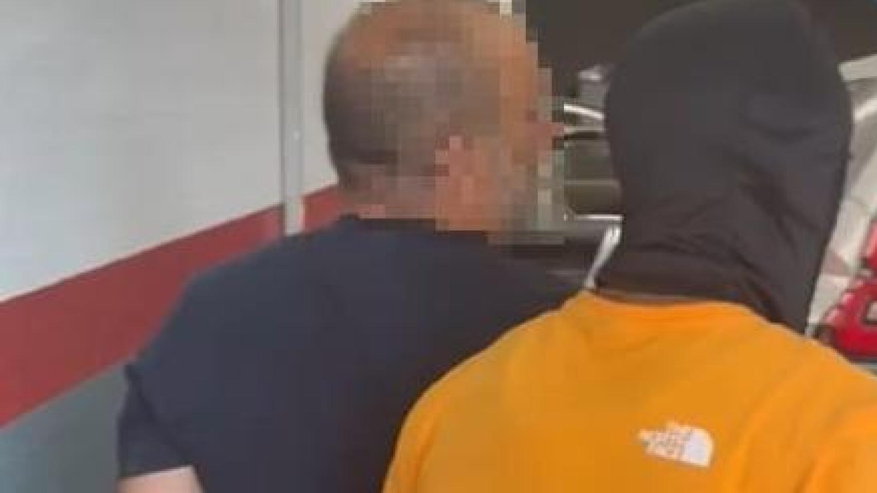 Un agente de la Policía Nacional de Huelva, con el detenido.