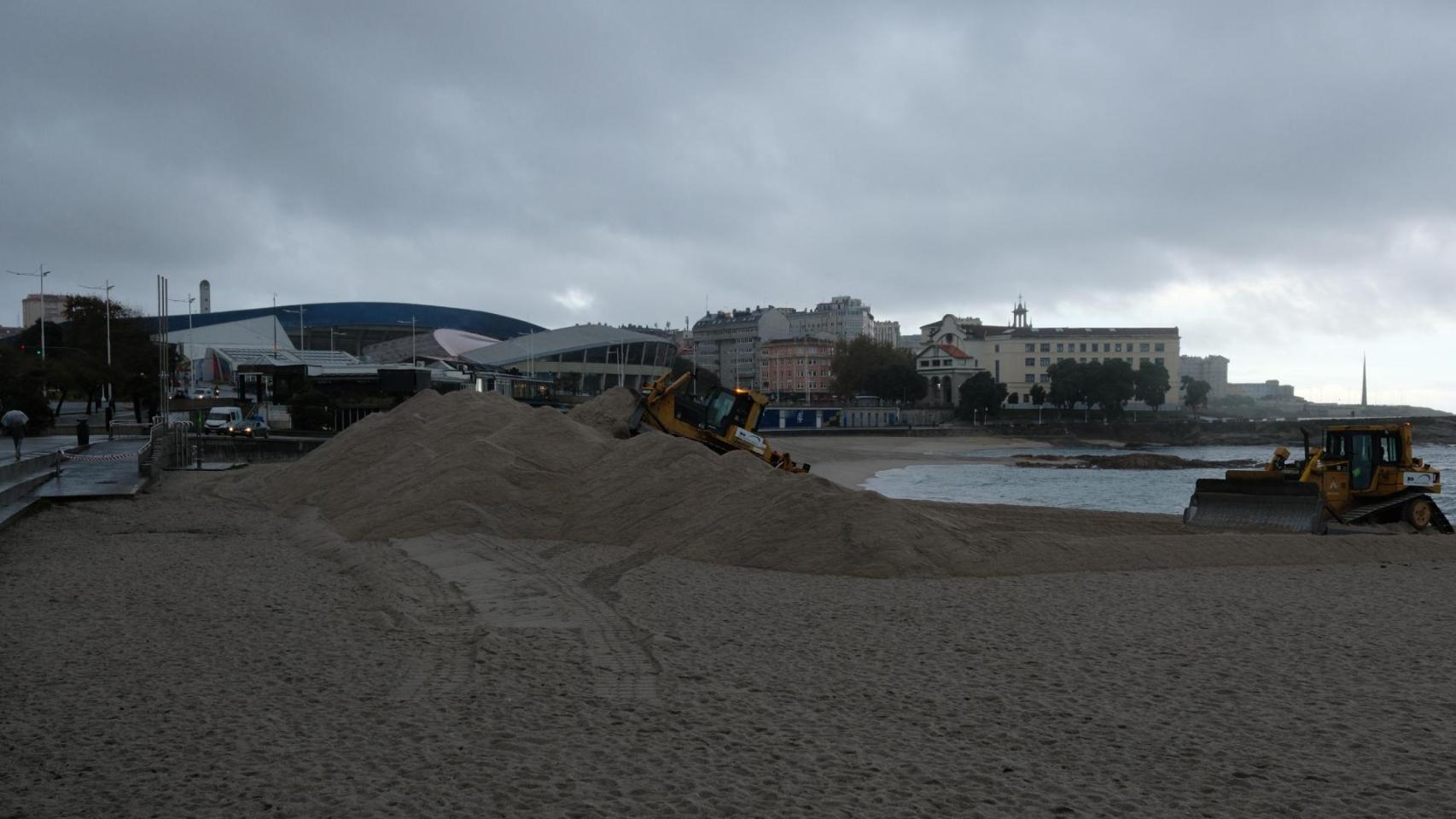 Una excavadora levanta la duna de Riazor este miércoles lluvioso.