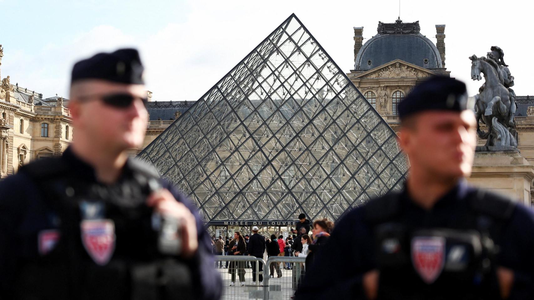 Agentes antidisturbios de la CRS francesa se encuentran cerca de la pirámide de cristal del Museo del Louvre , tras la detención por parte de la policía francesa de los sospechosos del robo del Louvre , en París, Francia, el 27 de octubre de 2025.