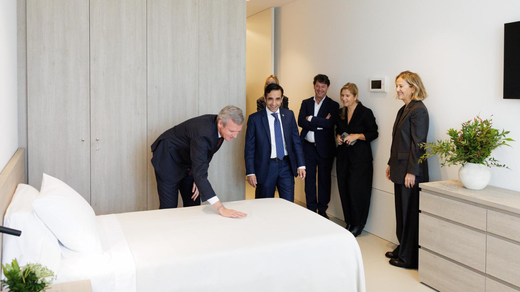 El presidente de la Xunta, Alfonso Rueda, visita una de las habitaciones de la residencia financiada por la Fundación Amancio Ortega junto a la presidenta de la entidad, Flora Pérez Marcote, y outras autoridades como el alcalde de Ferrol, José Manuel Rey.