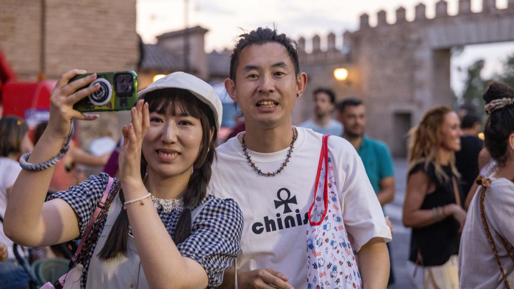 Una pareja de turistas japoneses junto a la Puerta de Bisagra, en Toledo.