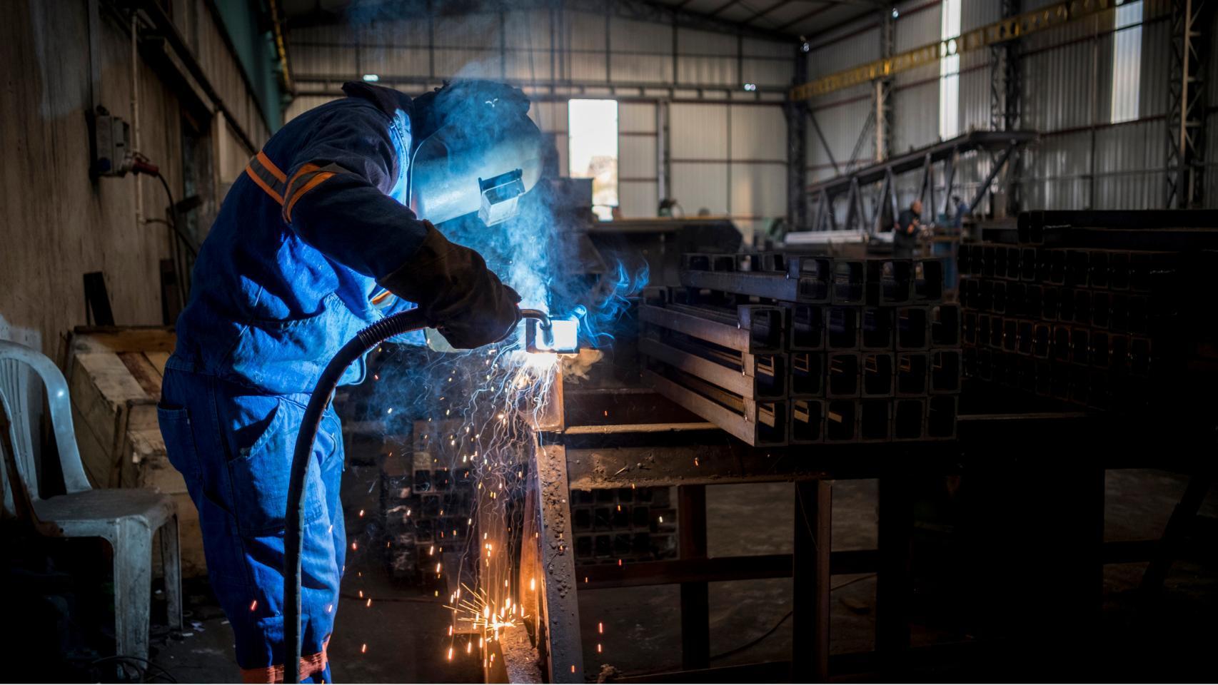 Persona trabajando en un taller metálico.