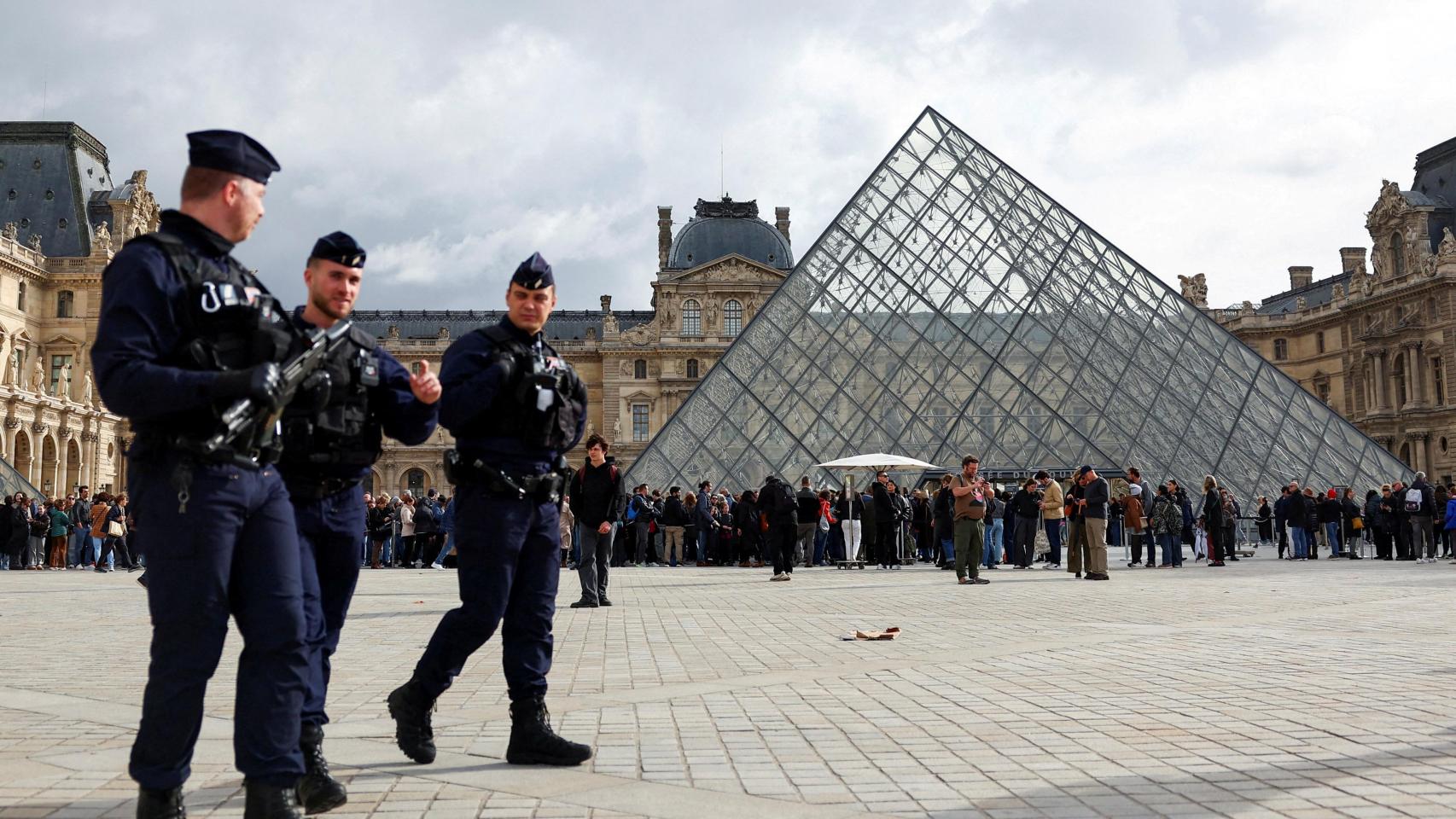 Fotografía de archivo en la que varios agentes custodian la entrada al Museo del Louvre.