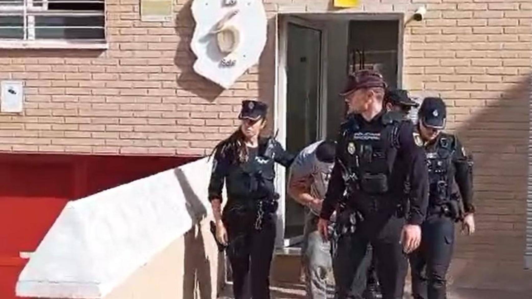 El presunto parricida de los apartamentos turísticos del Barrio de Santa María de Gracia de Murcia, este miércoles, custodiado por agentes de la Policía Local y de la Policía Nacional.