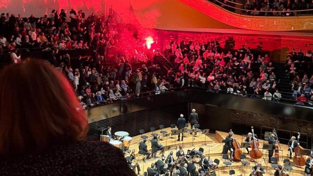 Momento en el que varios activistas interrumpen con bengalas el concierto de la Orquesta Filarmónica de Israel.