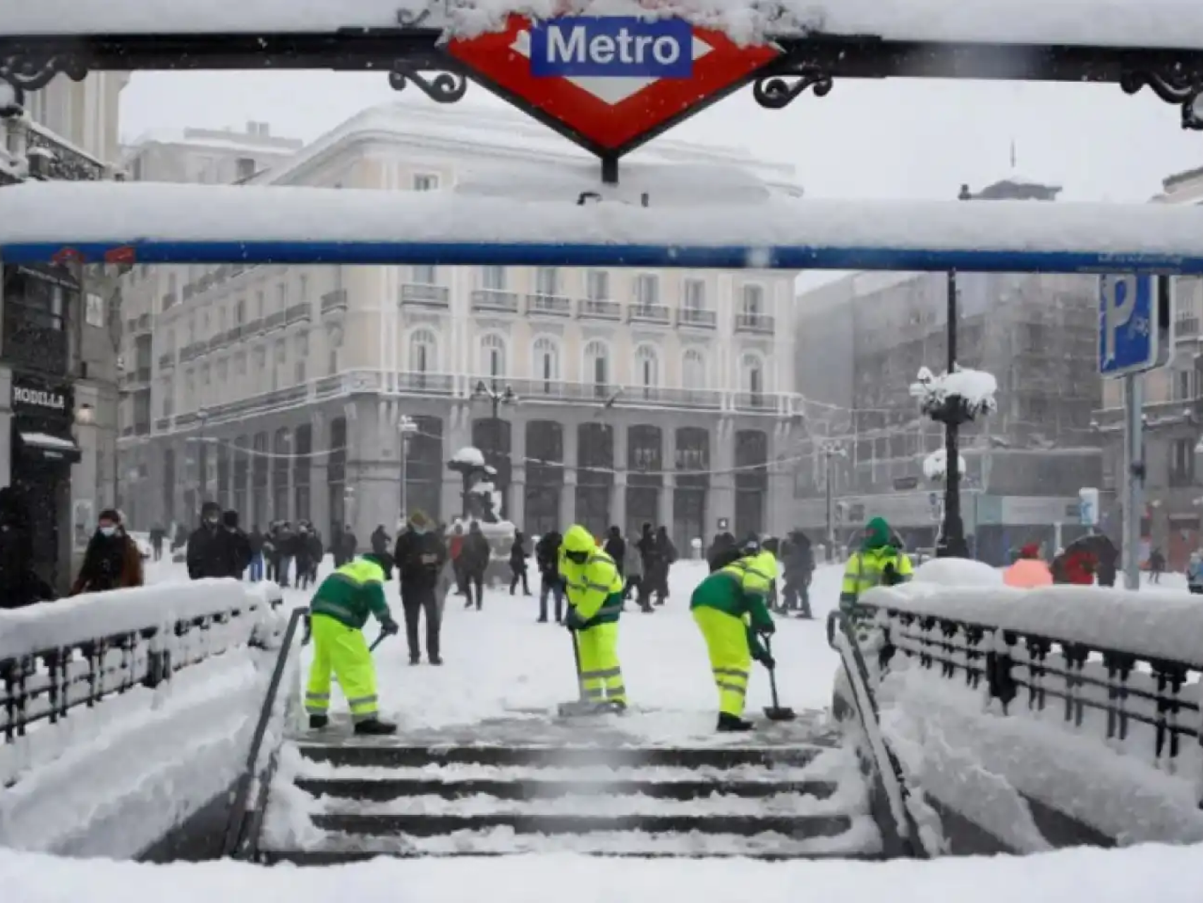 Unos operarios limpiando de nieve una estación de Metro de Madrid durante el temporal Filomena
