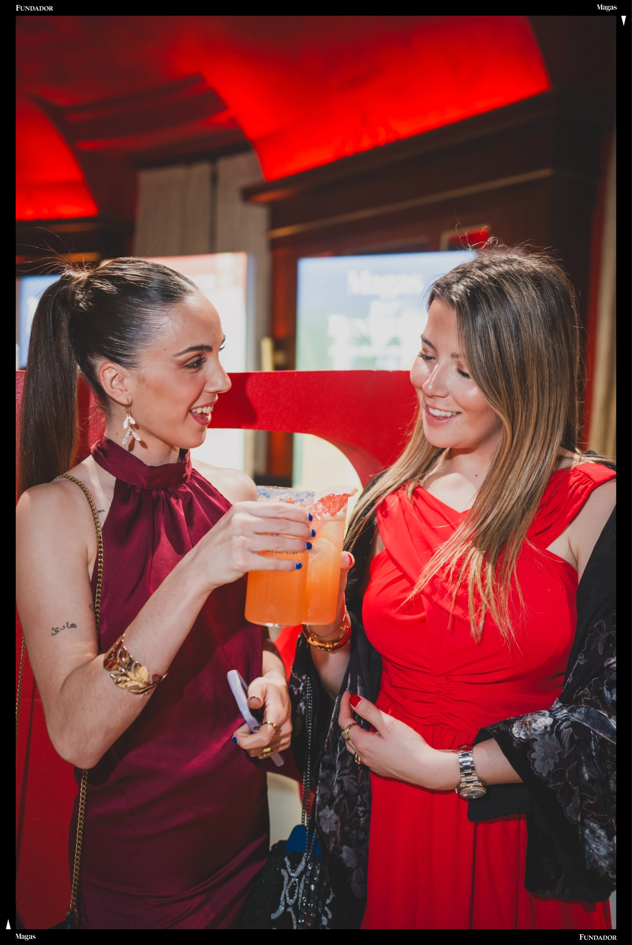 Dos invitadas brindan durante un evento social celebrado en un espacio interior
