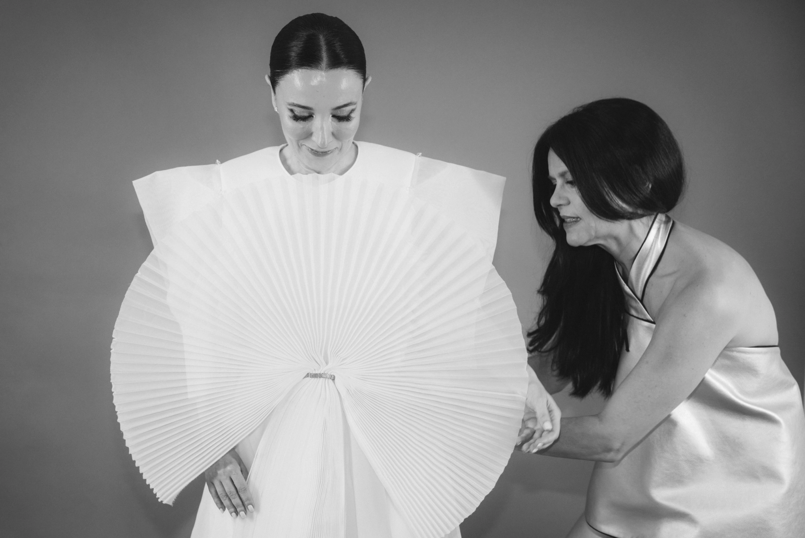 Foto dos de Pilar Dalbat, diseñadora, ayudando a Cruz Sánchez de Lara a probarse el vestido